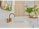 Close-up of a bathroom vanity with a marble countertop, gold faucet, and decorative mirror and lighting at 1010 Lake Shore Overlook, Alpharetta, GA 30005