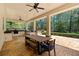 Spacious covered patio featuring an outdoor kitchen, a dining table, and views of the serene wooded landscape at 1010 Lake Shore Overlook, Alpharetta, GA 30005