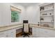 Bright home office with custom built-in desk, granite countertops, shelving, and a large window at 1010 Lake Shore Overlook, Alpharetta, GA 30005