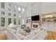 A spacious living room boasts a soaring ceiling, large windows, built-ins, and a cozy fireplace at 1010 Lake Shore Overlook, Alpharetta, GA 30005