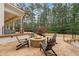 Inviting outdoor patio featuring stone fire pit, comfortable seating, and a serene backyard setting with mature trees at 1010 Lake Shore Overlook, Alpharetta, GA 30005