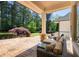 Covered patio with stone flooring featuring outdoor seating and overlooking a well-maintained grassy yard at 1010 Lake Shore Overlook, Alpharetta, GA 30005