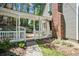 View of the covered backyard porch with brick chimney and lush landscaping at 1745 Shady Hill Ne Rd, Marietta, GA 30068