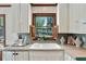 Bright kitchen with a farmhouse sink and shuttered windows overlooking the garden at 1745 Shady Hill Ne Rd, Marietta, GA 30068