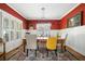 Bright dining room with red accent wall, wainscoting, wooden table, and stylish lighting fixture at 2964 Anderson Se Cir, Smyrna, GA 30080