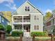 Charming two-story home boasts double porches, green siding, and a well-manicured front yard with mature trees at 2964 Anderson Se Cir, Smyrna, GA 30080