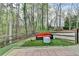Backyard patio with outdoor seating and a treeline beyond the grassy area at 3045 Hartridge Dr, Johns Creek, GA 30022