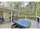 Inviting covered deck boasts comfortable seating and serene views of the surrounding trees at 3045 Hartridge Dr, Johns Creek, GA 30022