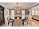 Stylish dining room with chandelier, decorative mirror, and view into the living room at 3045 Hartridge Dr, Johns Creek, GA 30022