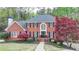 Charming red brick home with manicured lawn, mature trees, and beautiful landscaping at 3045 Hartridge Dr, Johns Creek, GA 30022