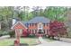 Exterior of a brick home with a manicured lawn, mature trees and a long driveway at 3045 Hartridge Dr, Johns Creek, GA 30022