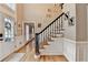 Inviting foyer with hardwood floors, staircase with wrought iron spindles and neutral walls at 3045 Hartridge Dr, Johns Creek, GA 30022