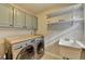 Practical laundry room with modern washer/dryer, sink, and ample storage space at 3045 Hartridge Dr, Johns Creek, GA 30022