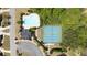 Aerial view showcasing a pristine community pool and tennis courts surrounded by mature trees at 622 Rocky Creek Pt, Woodstock, GA 30188
