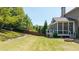 Beautiful backyard with a lush lawn, wooden fence, and a cozy screened-in porch area at 622 Rocky Creek Pt, Woodstock, GA 30188