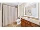 Well-lit bathroom featuring a shower with curtain, toilet, and a vanity with sink and countertop at 622 Rocky Creek Pt, Woodstock, GA 30188