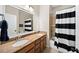 Bathroom with double sinks, wooden cabinets, a shower with curtain, and a wall-sized mirror at 622 Rocky Creek Pt, Woodstock, GA 30188