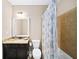 Well-lit bathroom featuring a vanity with marble countertop and a shower-tub combo with curtain at 622 Rocky Creek Pt, Woodstock, GA 30188