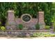Elegant community entrance sign with stone and brickwork surrounded by lush greenery and flowers at 622 Rocky Creek Pt, Woodstock, GA 30188