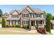 Charming two-story brick home with a manicured lawn and welcoming front porch at 622 Rocky Creek Pt, Woodstock, GA 30188