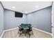 Well-lit game room with a TV, a poker table with chairs, and a door at 622 Rocky Creek Pt, Woodstock, GA 30188