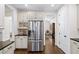 Bright kitchen features stainless steel refrigerator and custom cabinets with black countertops and wooden floors at 622 Rocky Creek Pt, Woodstock, GA 30188