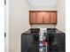 Functional laundry room with overhead cabinets and modern black washer and dryer units at 622 Rocky Creek Pt, Woodstock, GA 30188