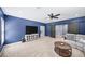 Spacious living room with blue walls, ceiling fan, modern furniture, and sliding barn doors at 622 Rocky Creek Pt, Woodstock, GA 30188