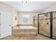 Elegant bathroom featuring a soaking tub, a separate shower, and a decorative window at 622 Rocky Creek Pt, Woodstock, GA 30188