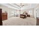 Bright main bedroom featuring a tray ceiling, large windows, a ceiling fan and carpet at 622 Rocky Creek Pt, Woodstock, GA 30188