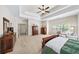 Carpeted main bedroom boasts trey ceilings, a ceiling fan, and ample closet space at 622 Rocky Creek Pt, Woodstock, GA 30188