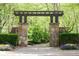Stone and wood walking bridge entrance provides a charming welcome amidst vibrant foliage at 622 Rocky Creek Pt, Woodstock, GA 30188