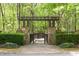Inviting walking bridge entrance surrounded by lush greenery and manicured landscaping at 622 Rocky Creek Pt, Woodstock, GA 30188