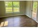 Neutral bedroom with a large window and a door to access a wood deck overlooking a green area at 8977 Teal Ln, Jonesboro, GA 30236