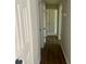 View down a hallway with wood floors and doors leading to various rooms in the house at 8977 Teal Ln, Jonesboro, GA 30236