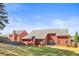 Expansive backyard with lush lawn, mature trees, and brick home exterior featuring a cozy patio at 105 Glenmore Ln, Mcdonough, GA 30253