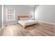 Spacious primary bedroom features hardwood floors, two windows, and neutral walls at 105 Glenmore Ln, Mcdonough, GA 30253