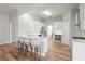 Bright kitchen features white cabinets, an island with bar stool seating, stainless steel appliances, and hardwood floors at 105 Glenmore Ln, Mcdonough, GA 30253