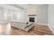 Modern living room with stylish fireplace, hardwood floors, and comfortable sofa, bathed in natural light at 105 Glenmore Ln, Mcdonough, GA 30253