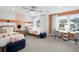 Bright bedroom featuring two twin beds, modern ceiling fan, two large windows, and a shared writing desk at 1636 Tide Mill Rd, Cumming, GA 30040