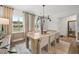 Modern dining room featuring a wooden table with six chairs, stylish lighting, and large windows at 1636 Tide Mill Rd, Cumming, GA 30040