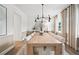 Elegant dining room with a large wooden table set for ten, modern chandelier, and neutral decor at 1636 Tide Mill Rd, Cumming, GA 30040