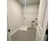 Clean laundry room featuring hexagon tile flooring, washer and dryer hookups, and a wire shelf for added storage at 1636 Tide Mill Rd, Cumming, GA 30040