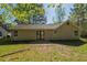 A view of the home's backyard featuring a patio and grassy area surrounded by mature trees at 6520 Emerald Pointe Cir, Atlanta, GA 30349