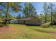 Expansive backyard showcasing a patio and lush lawn surrounded by mature trees at 6520 Emerald Pointe Cir, Atlanta, GA 30349