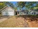 Charming single-story home with attached garage, manicured lawn, and mature trees at 6520 Emerald Pointe Cir, Atlanta, GA 30349