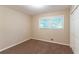 Neutral bedroom featuring a large window with tree views, plush carpeting, and a spacious closet at 8596 Timberlane Dr, Douglasville, GA 30134