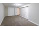 The carpeted bedroom has a single light fixture, base trim, and double bi-fold closet doors at 8596 Timberlane Dr, Douglasville, GA 30134