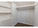 Walk-in closet featuring carpeted floors, white walls, and built-in shelving for optimal organization at 8596 Timberlane Dr, Douglasville, GA 30134