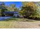 A single story home with brick accents, mature trees, carport, and a well-manicured front yard at 8596 Timberlane Dr, Douglasville, GA 30134